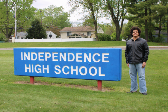 boy standing next to sign that reads independence high school